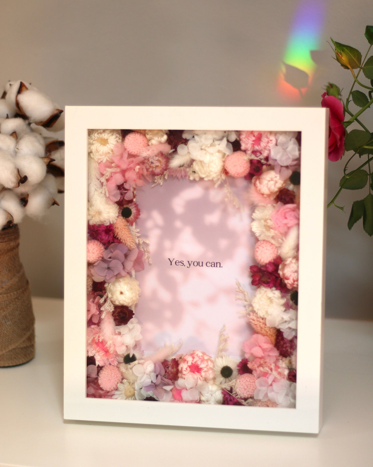 A white floral decorative photo frame with pink and white flowers