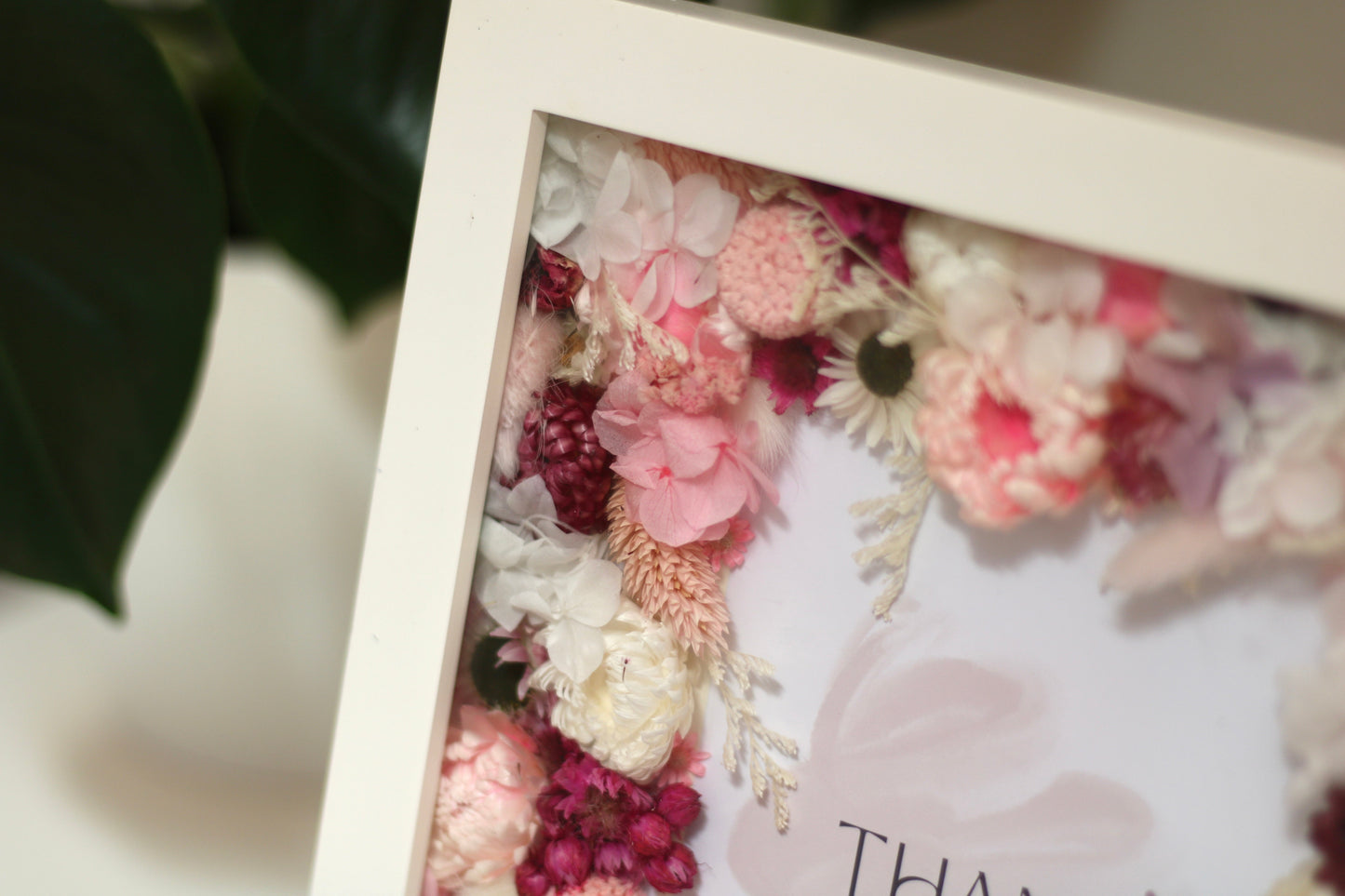 Closed up shot on a white picture frame with decorative flowers