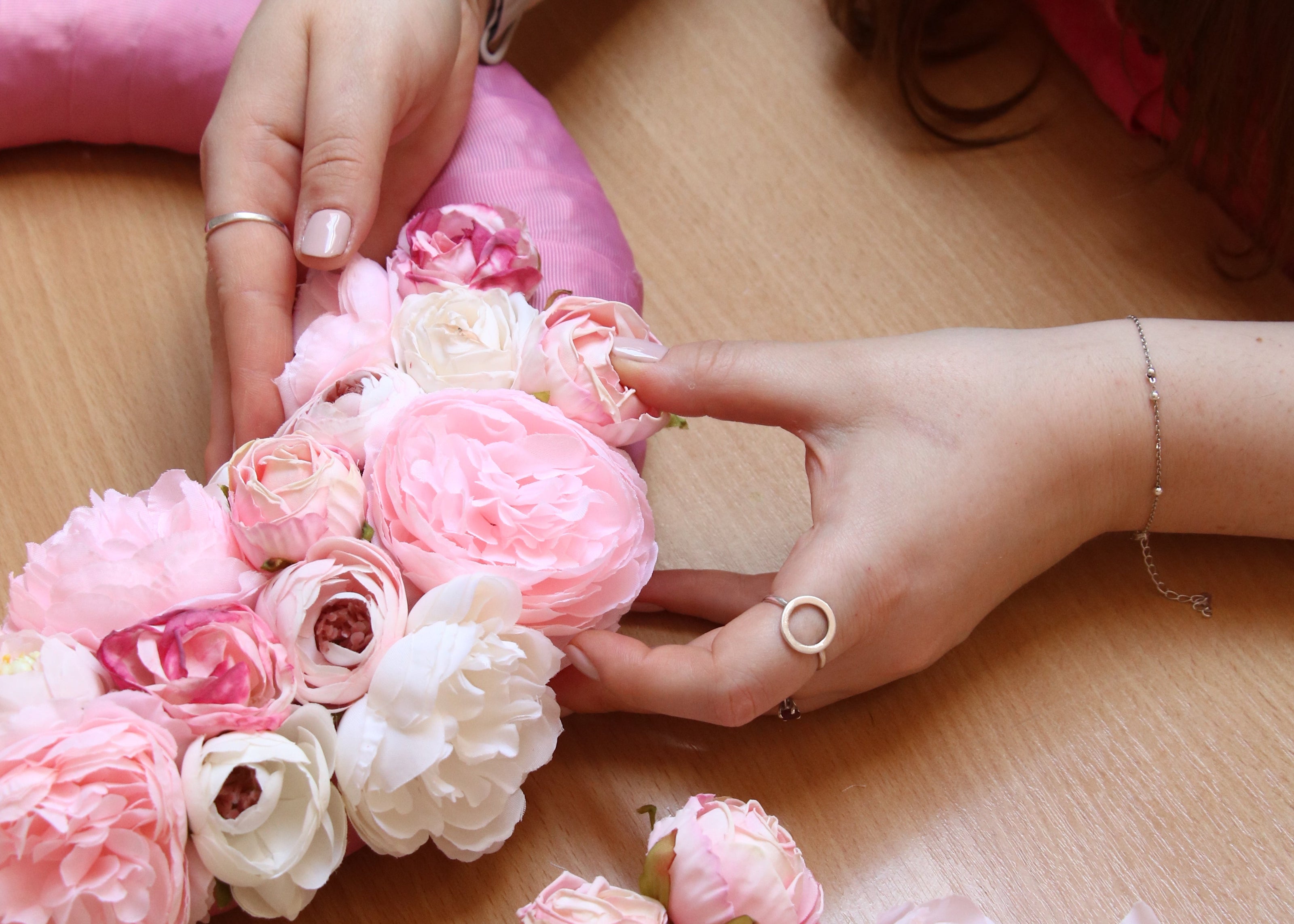 Woman's hans in the process of crafting an artificial floral wreath