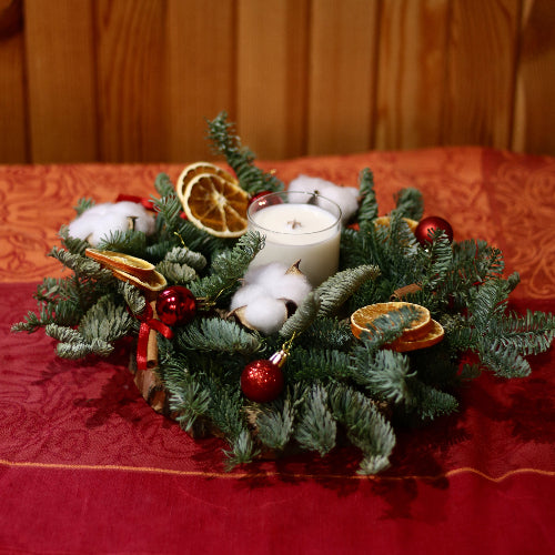 Evergreen wreath with orange slices and a candle in the middle