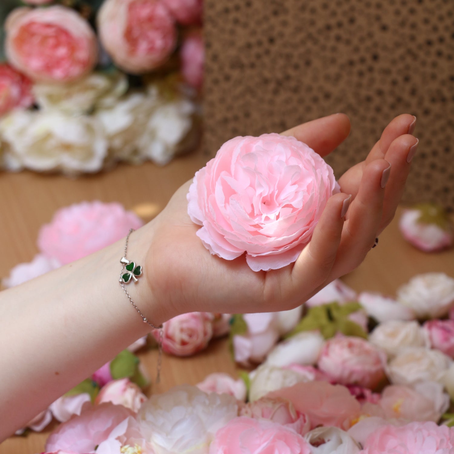 Hand holds a pink peony flower 