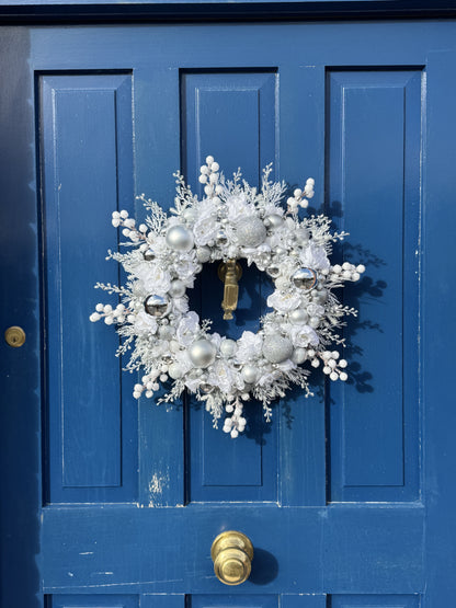 Decorative wreath on a blue door with gold door handles