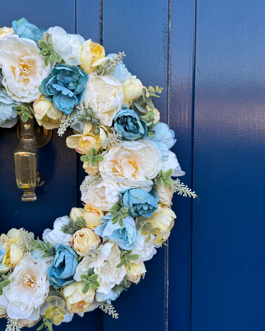 Half of a yellow and blue wreath of artificial flowers