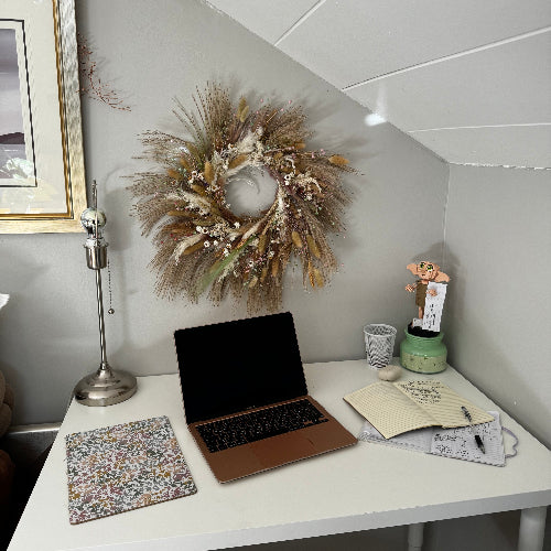 A wreath of stalks on a wall above a desk